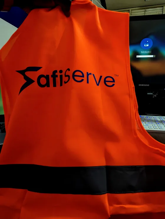 An orange reflective vest printed with the SafiServe logo.