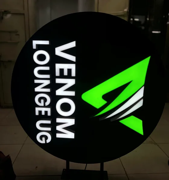 A round lit sign reading Venom Lounge UG with a green logo.