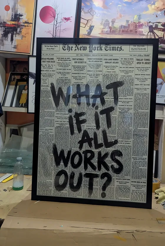 Framed print reading What if it all works out, lettered over newspaper.