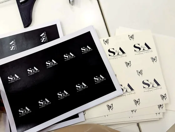 Sheets of printed S&A monogram labels in black and in white with butterflies.