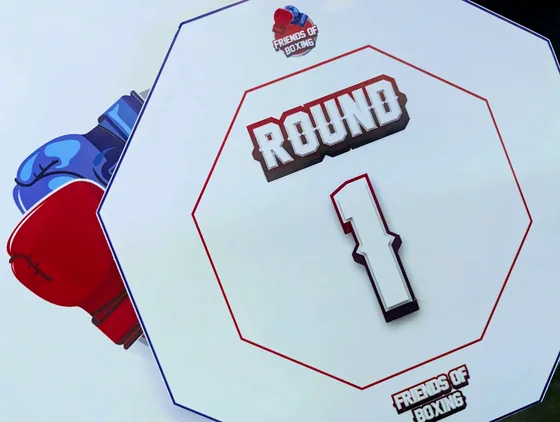 Octagonal Round 1 card with the Friends of Boxing logo beside boxing gloves.